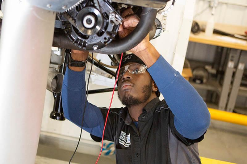 Male student working on airplane