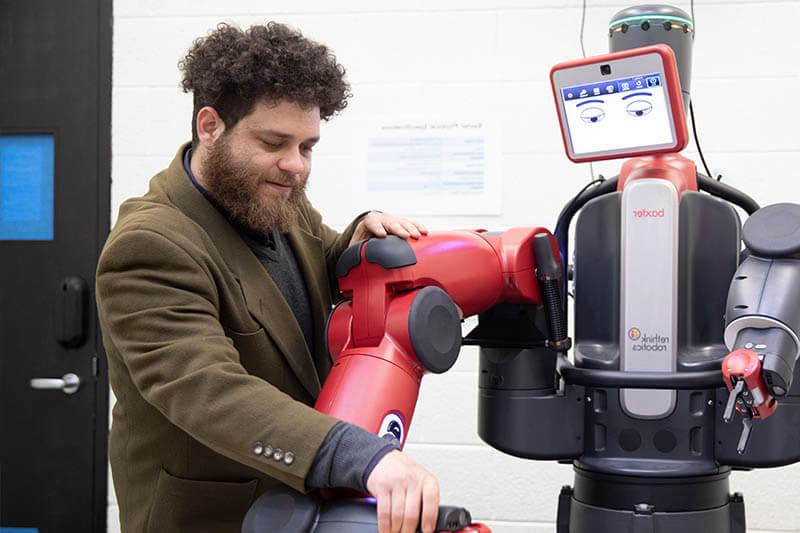 male student working on robot arm